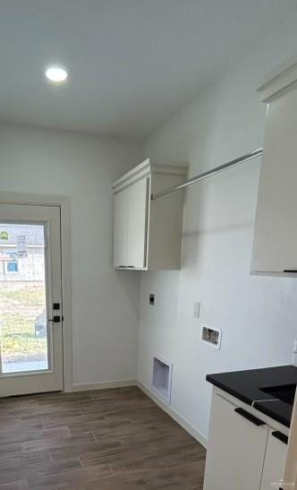 clothes washing area with hookup for a washing machine, visible vents, cabinet space, dark wood-type flooring, and electric dryer hookup