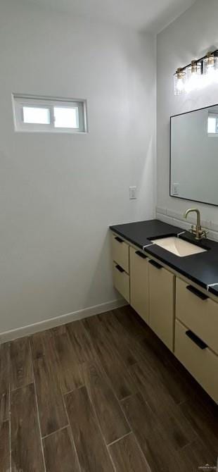 bathroom with wood finished floors, vanity, and baseboards