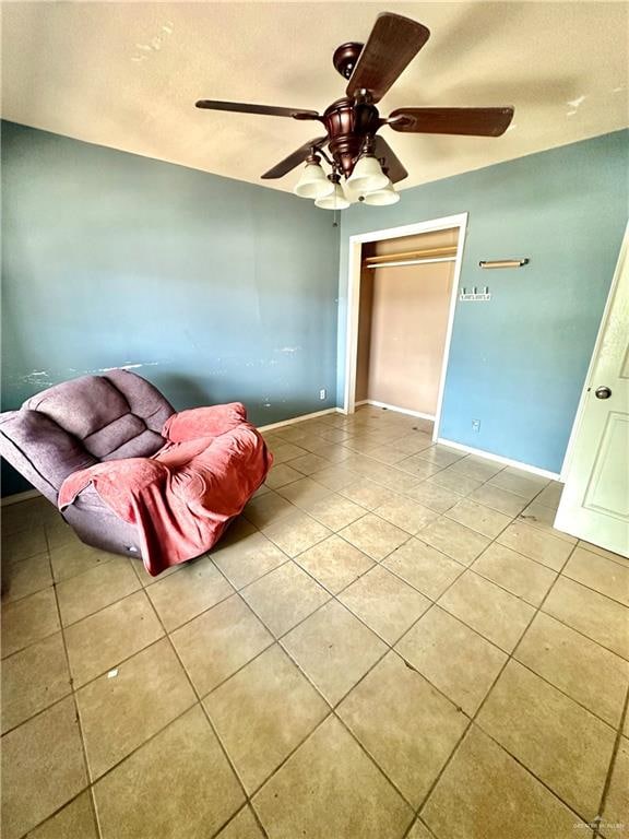 interior space with light tile patterned floors, a closet, and ceiling fan