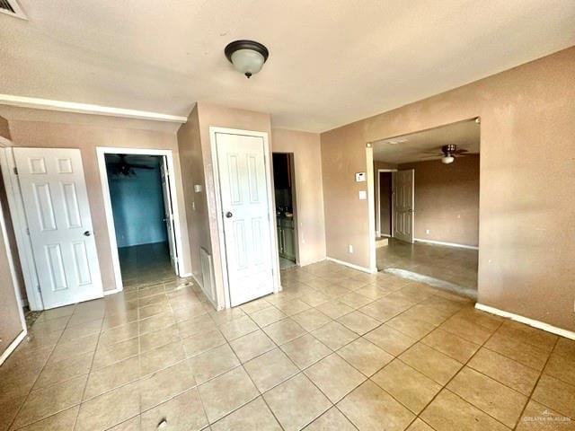 tiled spare room with ceiling fan