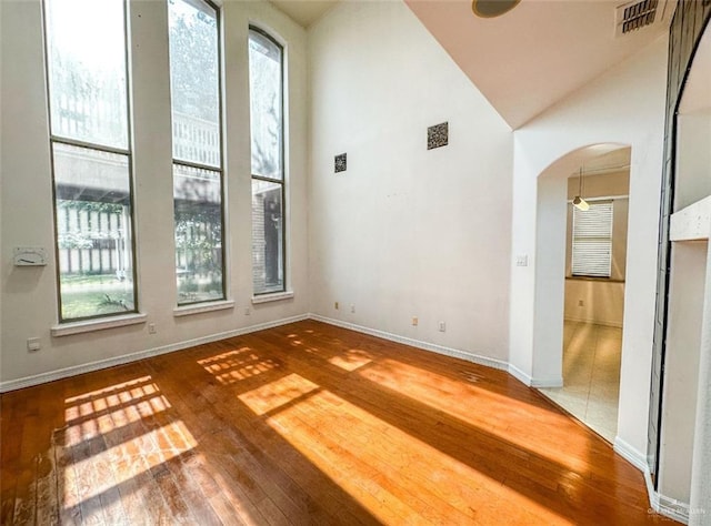 5605 N 41st St, Mcallen, TX 78504 - empty room featuring arched walkways, hardwood / wood-style flooring, baseboards, and vaulted ceiling