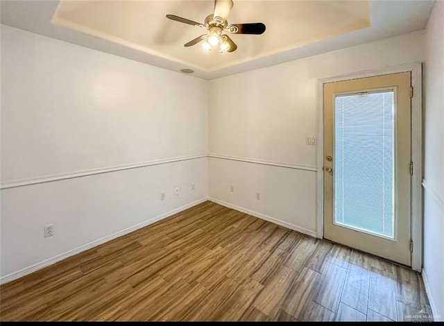 5605 N 41st St, Mcallen, TX 78504 - spare room featuring a tray ceiling, wood finished floors, baseboards, and a ceiling fan