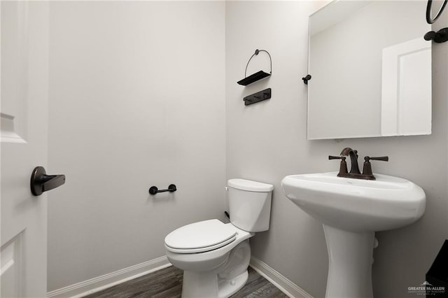 bathroom featuring baseboards, toilet, and wood finished floors