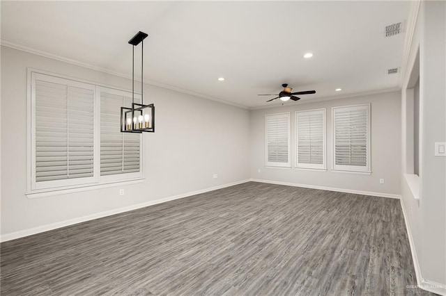 unfurnished room with baseboards, dark wood finished floors, visible vents, and crown molding