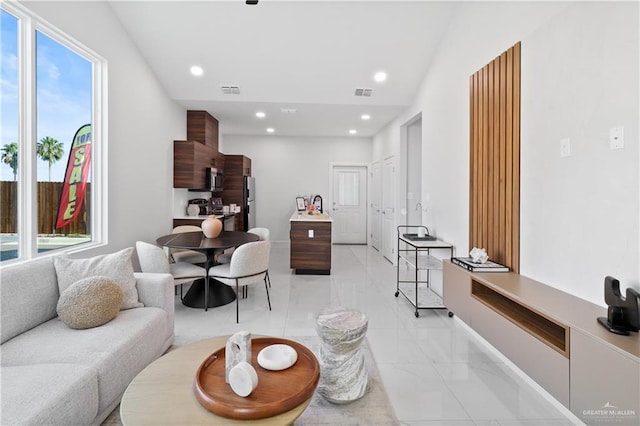 living area with recessed lighting, visible vents, and marble finish floor