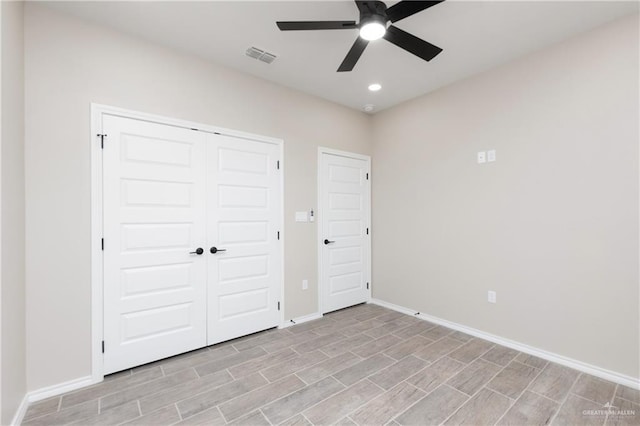 unfurnished bedroom with ceiling fan and a closet