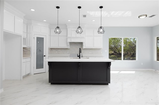 kitchen with visible vents, white cabinetry, light countertops, and a sink