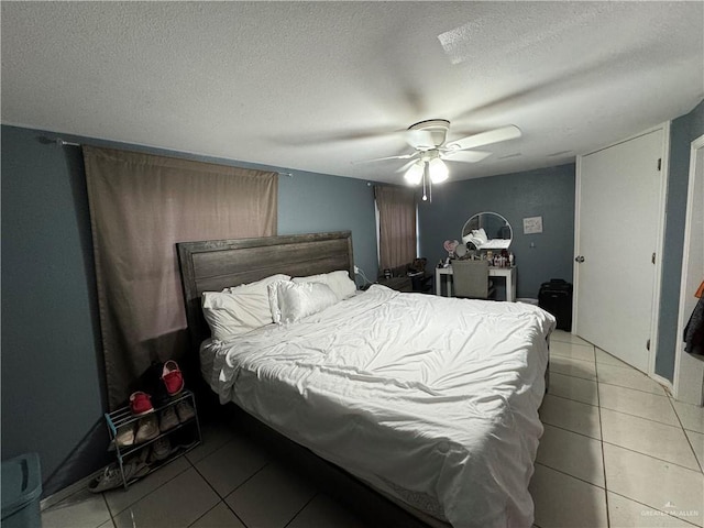 tiled bedroom featuring ceiling fan and a textured ceiling