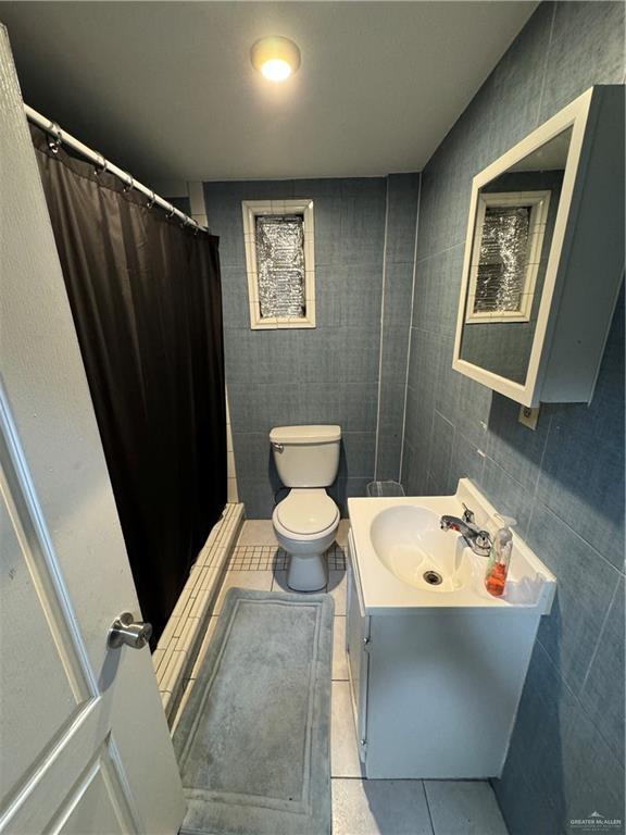 bathroom with vanity, a shower with curtain, tile patterned floors, and toilet