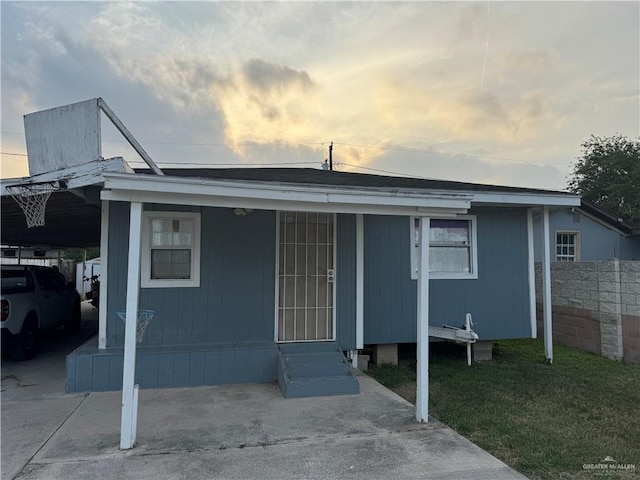 view of front of property featuring a carport and a yard