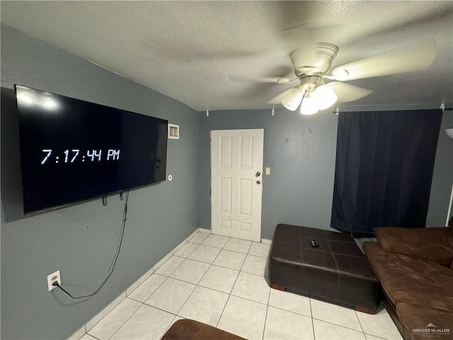 tiled living room featuring ceiling fan and a textured ceiling