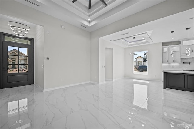 interior space featuring marble finish floor, visible vents, baseboards, and a raised ceiling