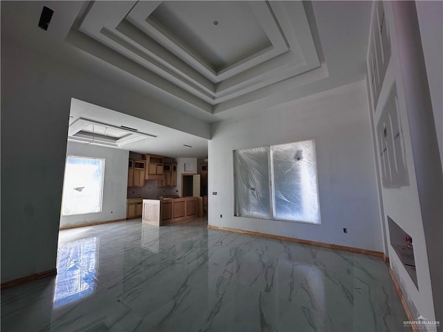 unfurnished living room featuring a tray ceiling