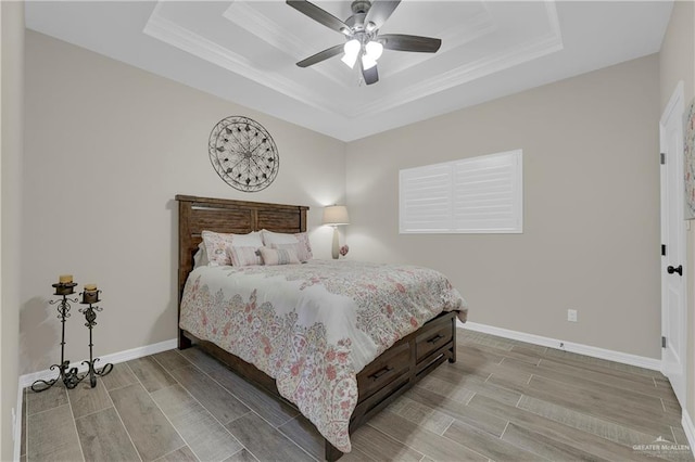 bedroom with a raised ceiling, ceiling fan, crown molding, and light hardwood / wood-style floors