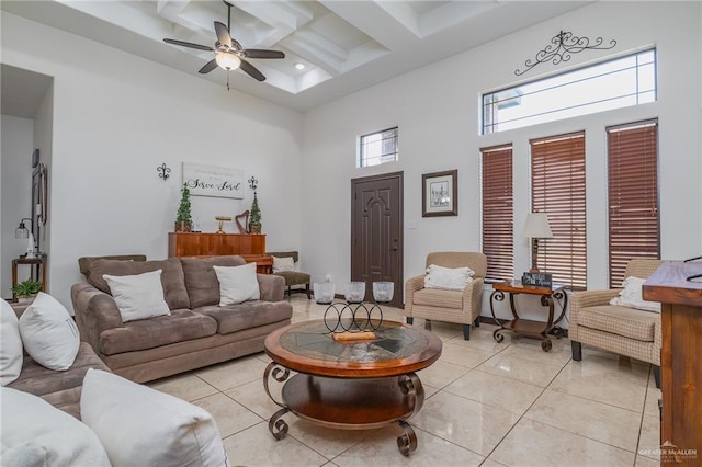 living room with beam ceiling, coffered ceiling, a high ceiling, and light tile patterned floors