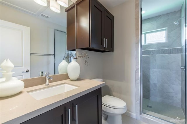 bathroom with vanity, toilet, a stall shower, and visible vents