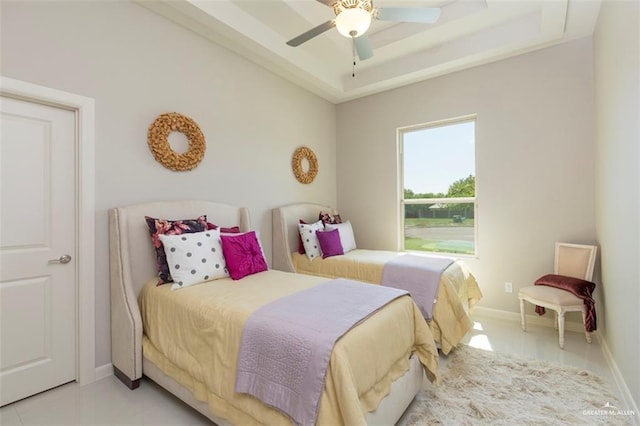bedroom featuring baseboards, ceiling fan, and a tray ceiling