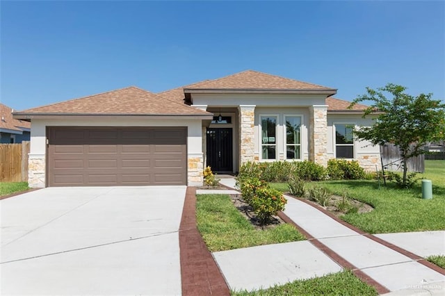 prairie-style home featuring a front lawn, stone siding, concrete driveway, a garage, and stucco siding