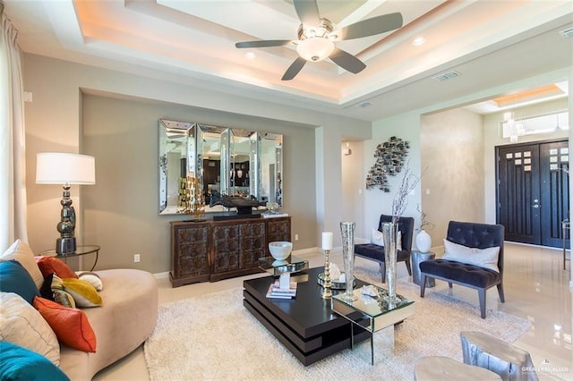 living area featuring recessed lighting, a raised ceiling, visible vents, baseboards, and ceiling fan