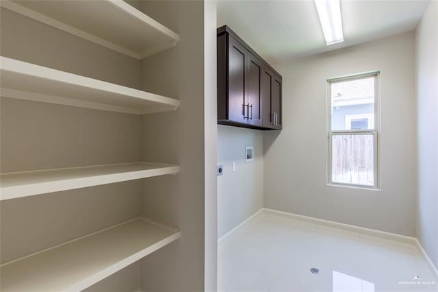 laundry room with hookup for an electric dryer, cabinet space, hookup for a washing machine, and baseboards