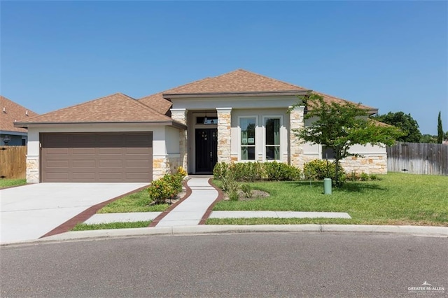 view of front facade featuring fence, driveway, stone siding, a front yard, and a garage