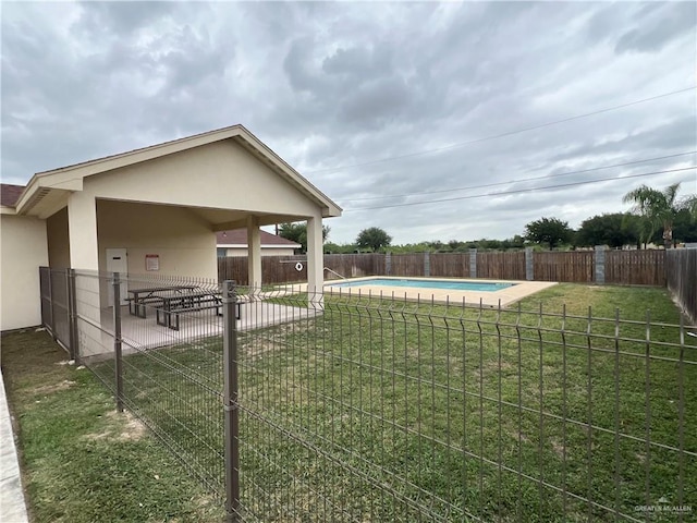 view of yard with a community pool, a patio area, and a fenced backyard