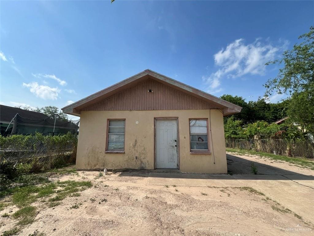 back of property featuring fence and stucco siding