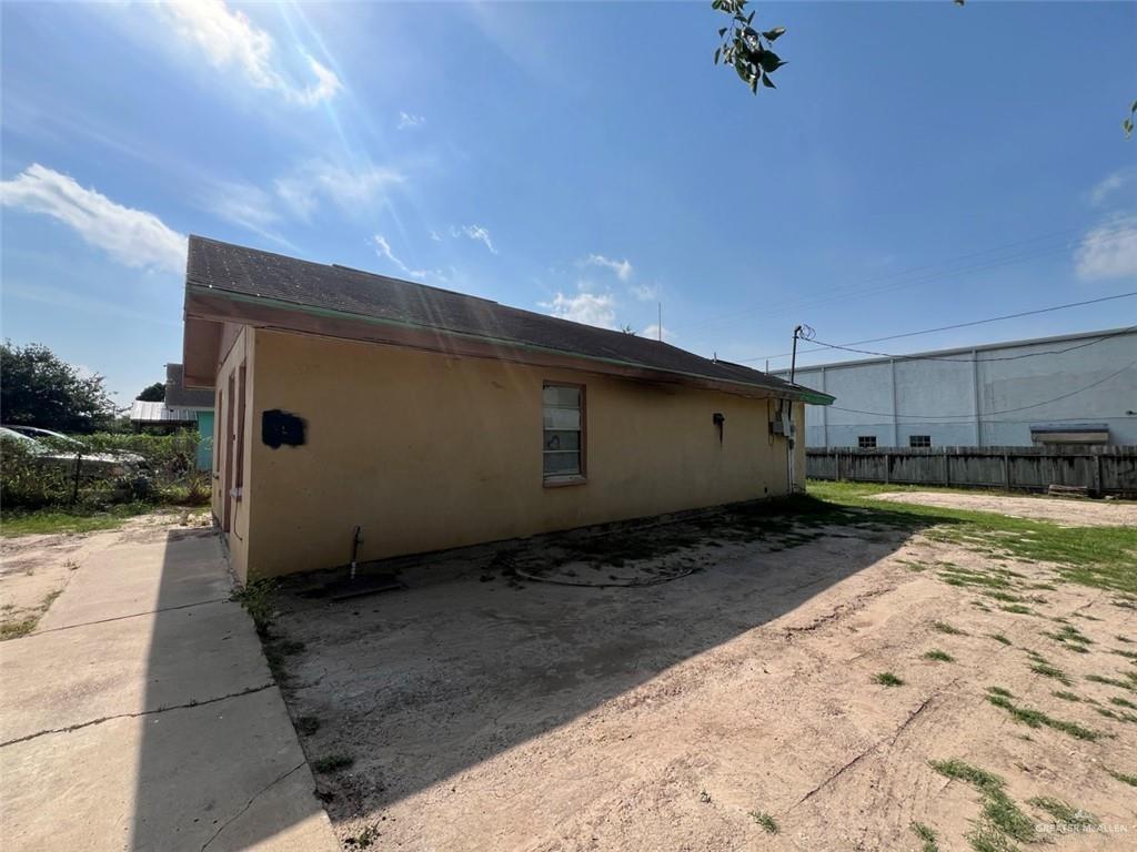 view of property exterior with stucco siding and fence