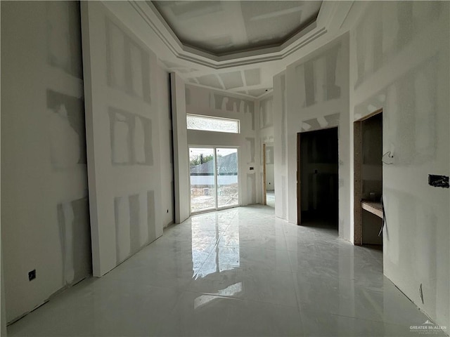 spare room featuring crown molding and a high ceiling