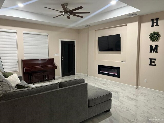 2429 Summer Breeze St, Mission, TX 78574 - living room with a ceiling fan, marble finish floor, a glass covered fireplace, visible vents, and a raised ceiling