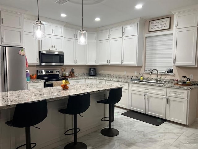 2429 Summer Breeze St, Mission, TX 78574 - kitchen featuring decorative light fixtures, marble finish floor, a sink, stainless steel appliances, and white cabinets