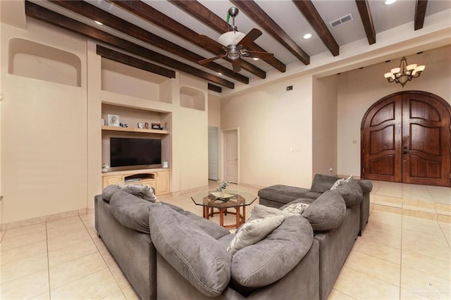 living room with beamed ceiling, ceiling fan with notable chandelier, built in features, and light tile patterned flooring