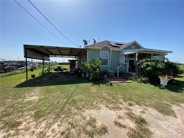 view of front of property with solar panels, a front yard, and a carport