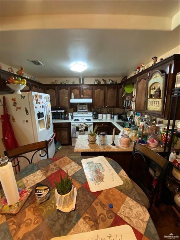 kitchen featuring dark brown cabinetry, white appliances, sink, and extractor fan