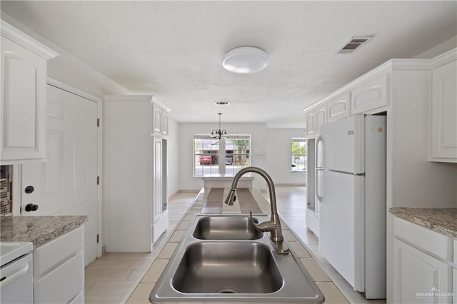 2216 Fairmont Ave, Mcallen, TX 78504 - kitchen featuring freestanding refrigerator, white cabinets, light countertops, and hanging light fixtures