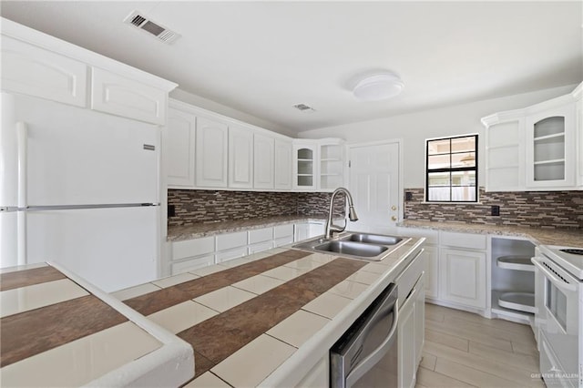 2216 Fairmont Ave, Mcallen, TX 78504 - kitchen with white appliances, tasteful backsplash, glass insert cabinets, and white cabinets