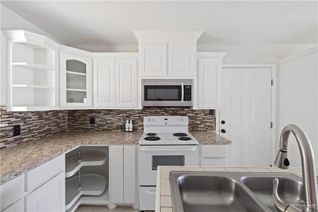 2216 Fairmont Ave, Mcallen, TX 78504 - kitchen with stainless steel microwave, electric stove, white cabinetry, and tasteful backsplash