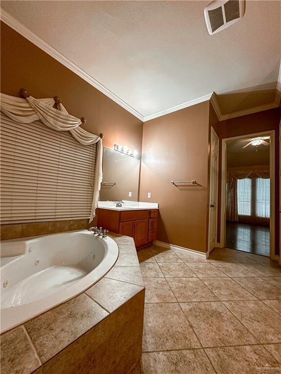 bathroom featuring tiled tub, vanity, and ornamental molding