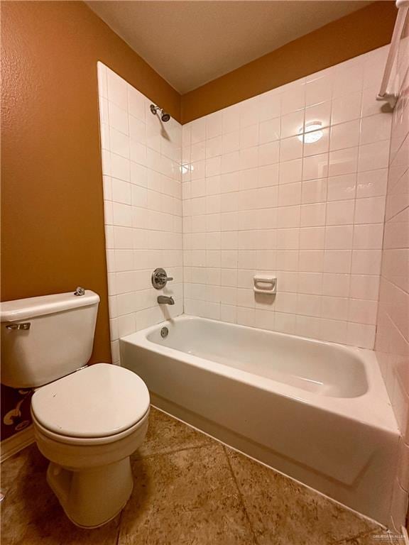 bathroom with toilet and tiled shower / bath