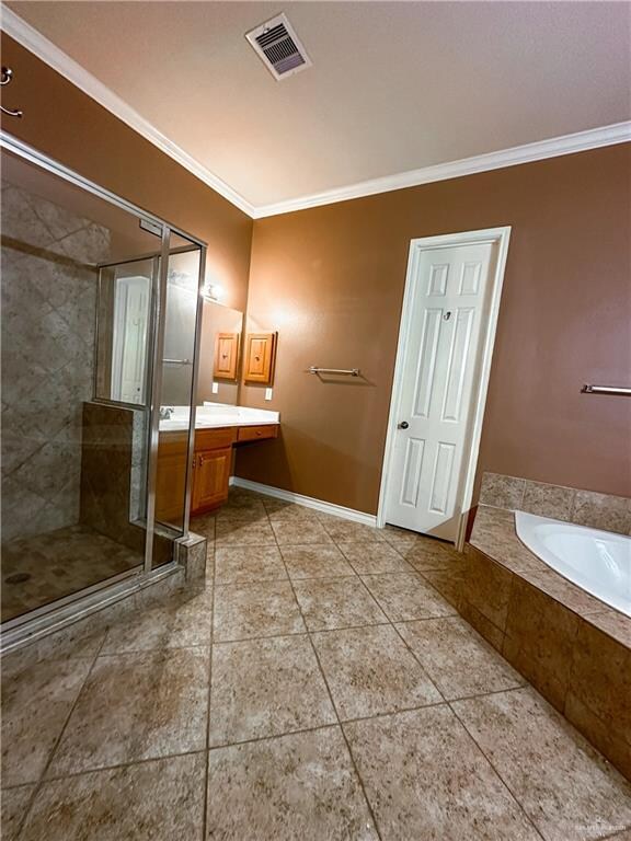 bathroom featuring plus walk in shower, tile patterned flooring, vanity, and ornamental molding