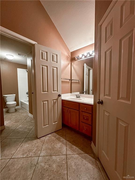 bathroom featuring tile patterned floors, vanity, toilet, and vaulted ceiling