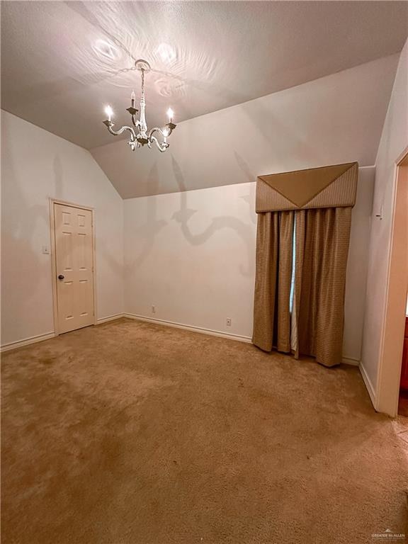 additional living space with lofted ceiling, carpet floors, and a chandelier