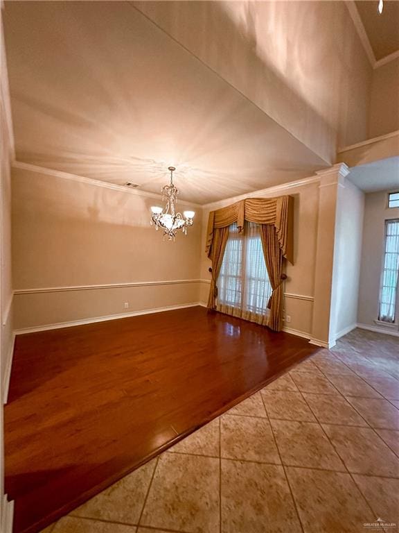 interior space featuring hardwood / wood-style floors, an inviting chandelier, a wealth of natural light, and ornate columns