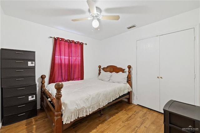 bedroom featuring ceiling fan, wood-type flooring, and a closet