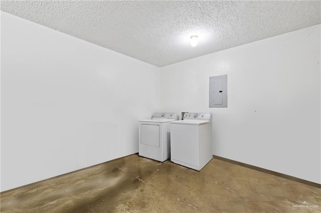 laundry area featuring washing machine and dryer, electric panel, and a textured ceiling