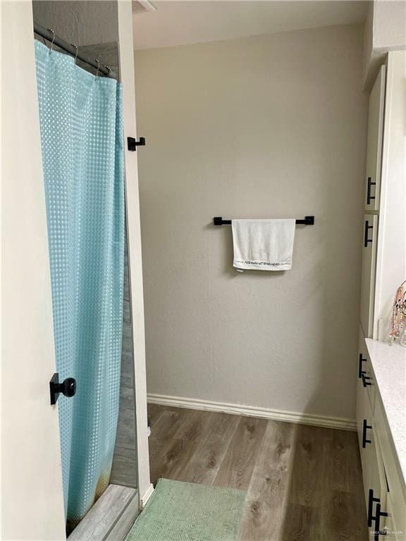 bathroom featuring wood-type flooring, curtained shower, and vanity