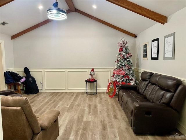 living room featuring lofted ceiling with beams and light wood-type flooring