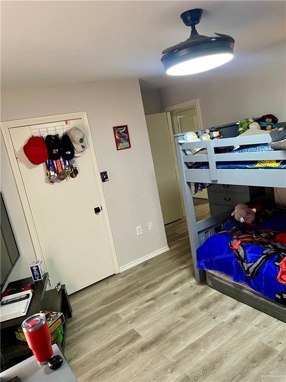 bedroom featuring white refrigerator and light hardwood / wood-style flooring