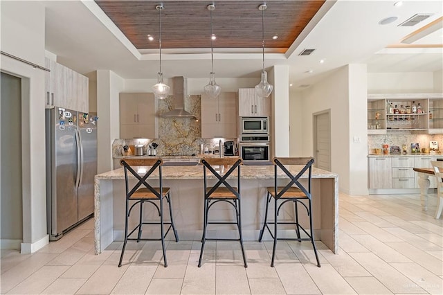 2520 Colvin Ave, Edinburg, TX 78539 - kitchen featuring wall chimney range hood, stainless steel appliances, hanging light fixtures, and a tray ceiling