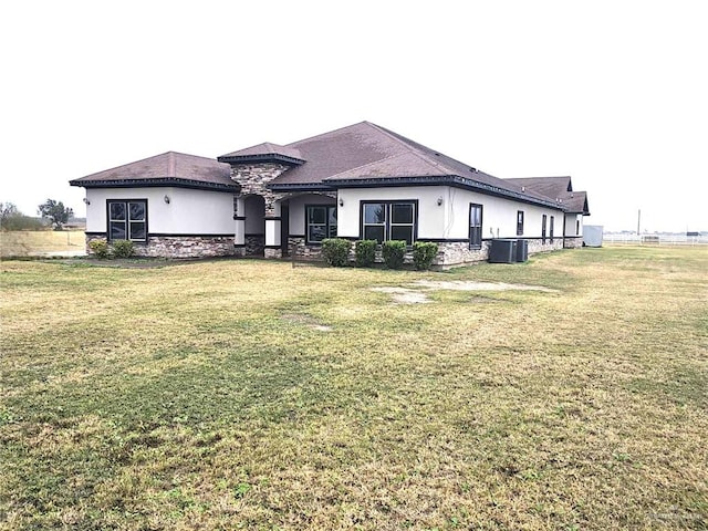 view of front of home featuring central air condition unit and a front yard